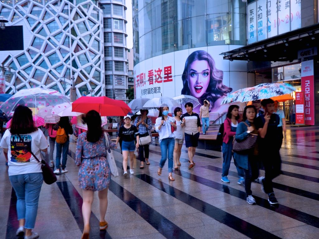 Umbrella-clad pedestrians don't let a little (or a lot) of rain get the best of their shopping experience in Dongdaemun Design Plaza in Seoul